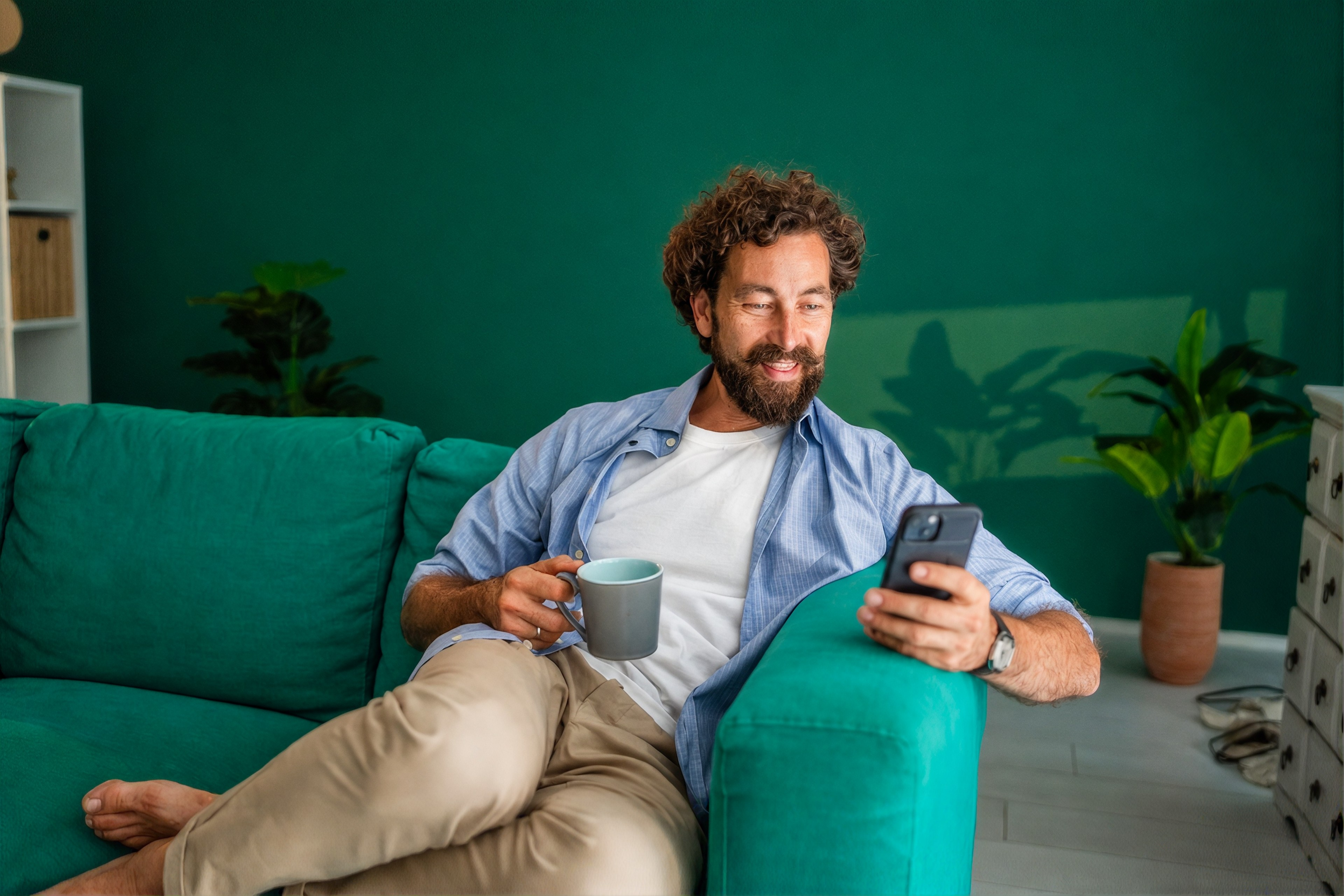 A man talking to his AI phone agent from the comfort of his sofa